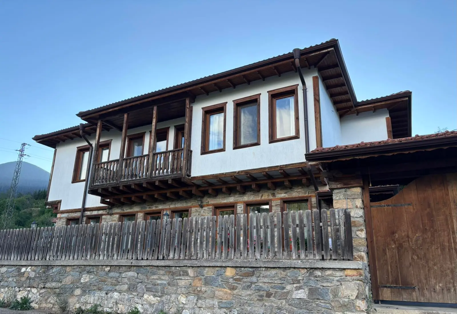 House Maria's facade with its stone base and wooden bay windows